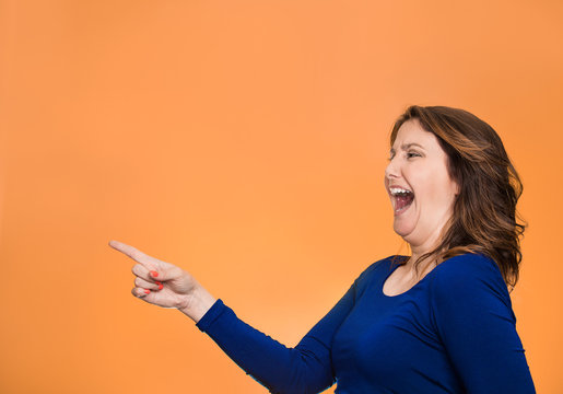 Side profile happy laughing woman pointing finger at something