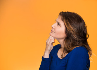 Headshot woman thinking looking up isolated orange background 