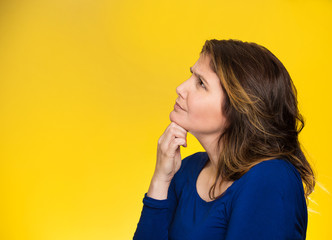 woman thinking looking up isolated on yellow background 