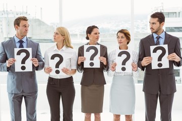 Business people holding question mark signs