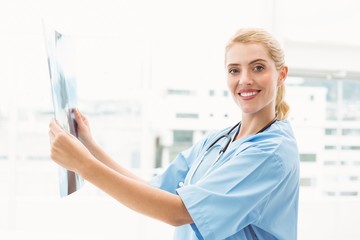 Smiling female doctor examining x-ray