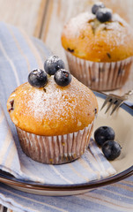Homemade Muffins with fresh blueberries on   wooden table