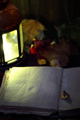 Open blank book near a lantern
