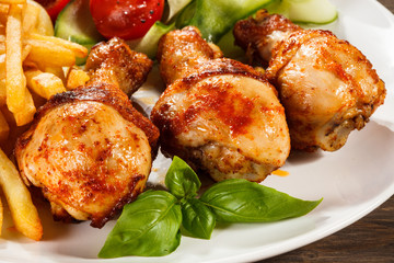 Grilled chicken legs with chips and vegetables