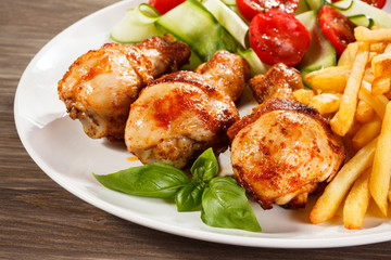 Grilled chicken legs with chips and vegetables