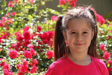 lovely brunette girl with the background of red roses