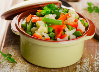 Mixed vegetables in a bowl on  a wooden board