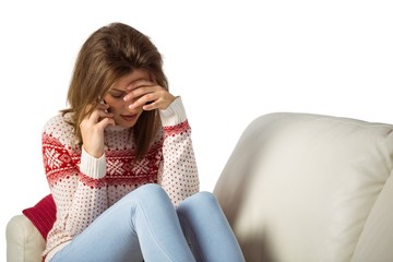 Upset young woman looking down while calling on phone