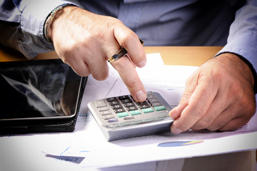 Businessman Using Calculator In Office