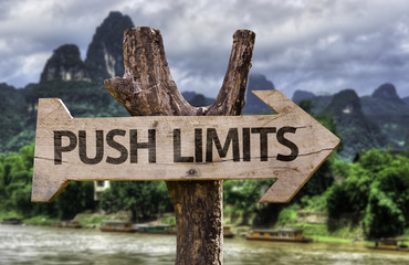 Push Limits wooden sign with a forest background
