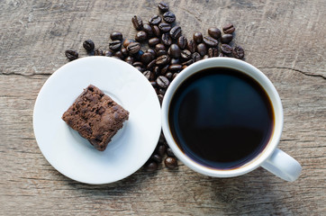 Black coffee with chocolate brownie on grained wood