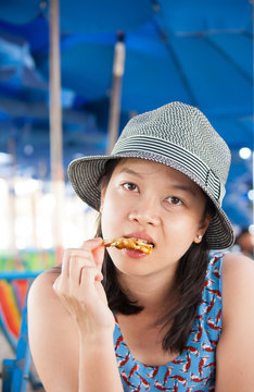 Woman eating seafood outside in summer smiling happy at camera.