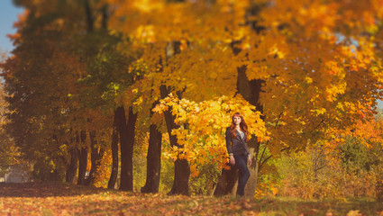 beautiful woman with red hair in autumn park