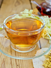 Tea from meadowsweet in cup and teapot on board