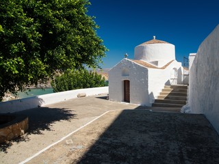 Typical feature from greek country, religious architecture. Small chapel on blue sky background.