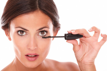 Afraid woman with brown eyes applying mascara
