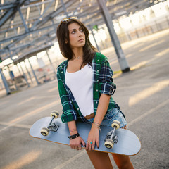 Teenager with skateboard portrait outdoors in a parking area.