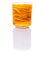 Home remedy of lemon slices and honey in a glass jar over white 