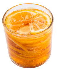 Home remedy of lemon slices and honey in a glass jar over white 