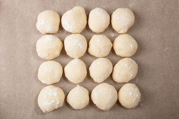 Fototapeta na wymiar Small balls of dough with flour for pizza or cakes and scones on