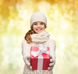 Fototapeta na wymiar dreaming girl in winter clothes with gift box