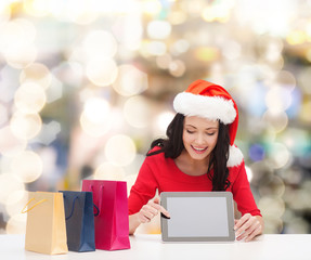 smiling woman with shopping bags and tablet pc