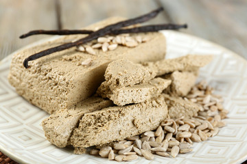Sunflower halva on plate, on wooden background