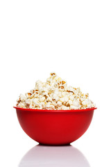 Red bowl with popcorn isolated on white