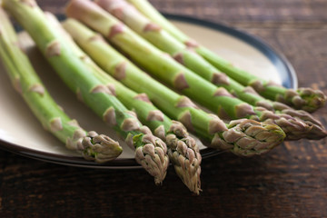Asparagus on a white plate on the wooden table