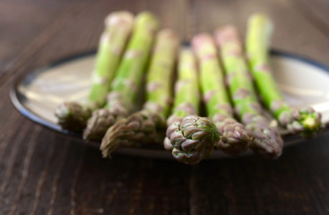 Asparagus on a white plate on the wooden table