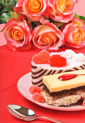 Valentine cakes, tarts and red roses on the red tablecloth