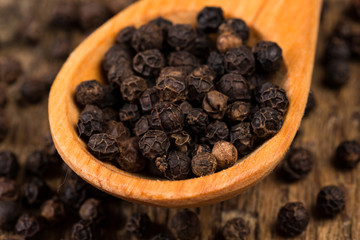 black pepper on wooden spoon