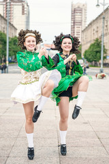 Obraz premium Two women in irish dance dresses and wig dancing