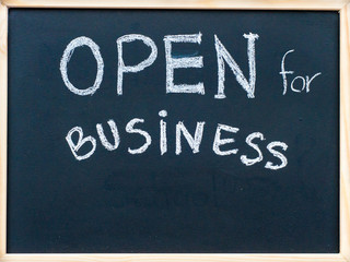 Open for business message handwritten on blackboard