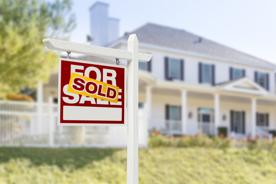 A sold sign in front of a new home.