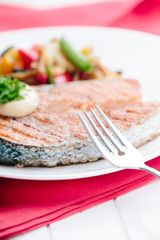 Grilled Salmon with Fresh vegetables on red background