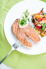 Grilled Salmon with Fresh vegetables on green background