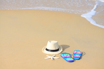 Fototapeta na wymiar slippers with hat on the beach