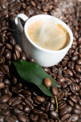 cup of coffee with a smoke and roasted coffee beans