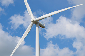 wind turbine against cloudy blue sky background