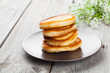 Fototapeta na wymiar Delicious pancakes with raspberries sauce on the wooden kitchen