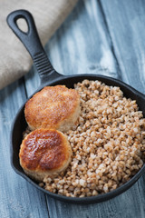 Frying pan with meat cutlets and buckwheat, studio shot