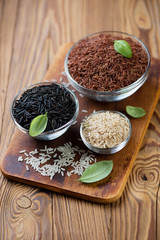 Variety of raw rice, rustic wooden background, studio shot
