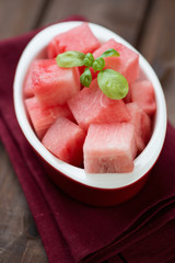 Vertical shot of a glass bowl with watermelon cubes, close-up