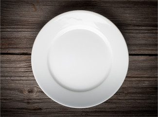 Empty white plate on wooden table