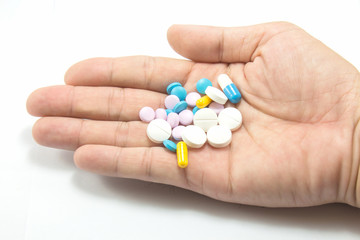 Diferent tablets pills heap mix in hand on white isolated backgr