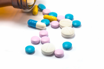Diferent tablets pills heap mix on white isolated background