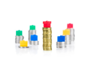 Stacked coins with toy houses with shallow depth of field