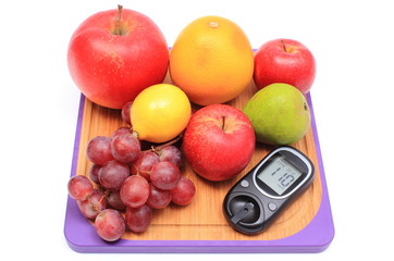 Fresh natural fruits with glucose meter on cutting board