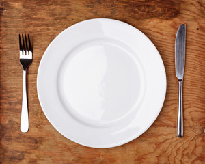 Knife, Fork and plate on wooden table.